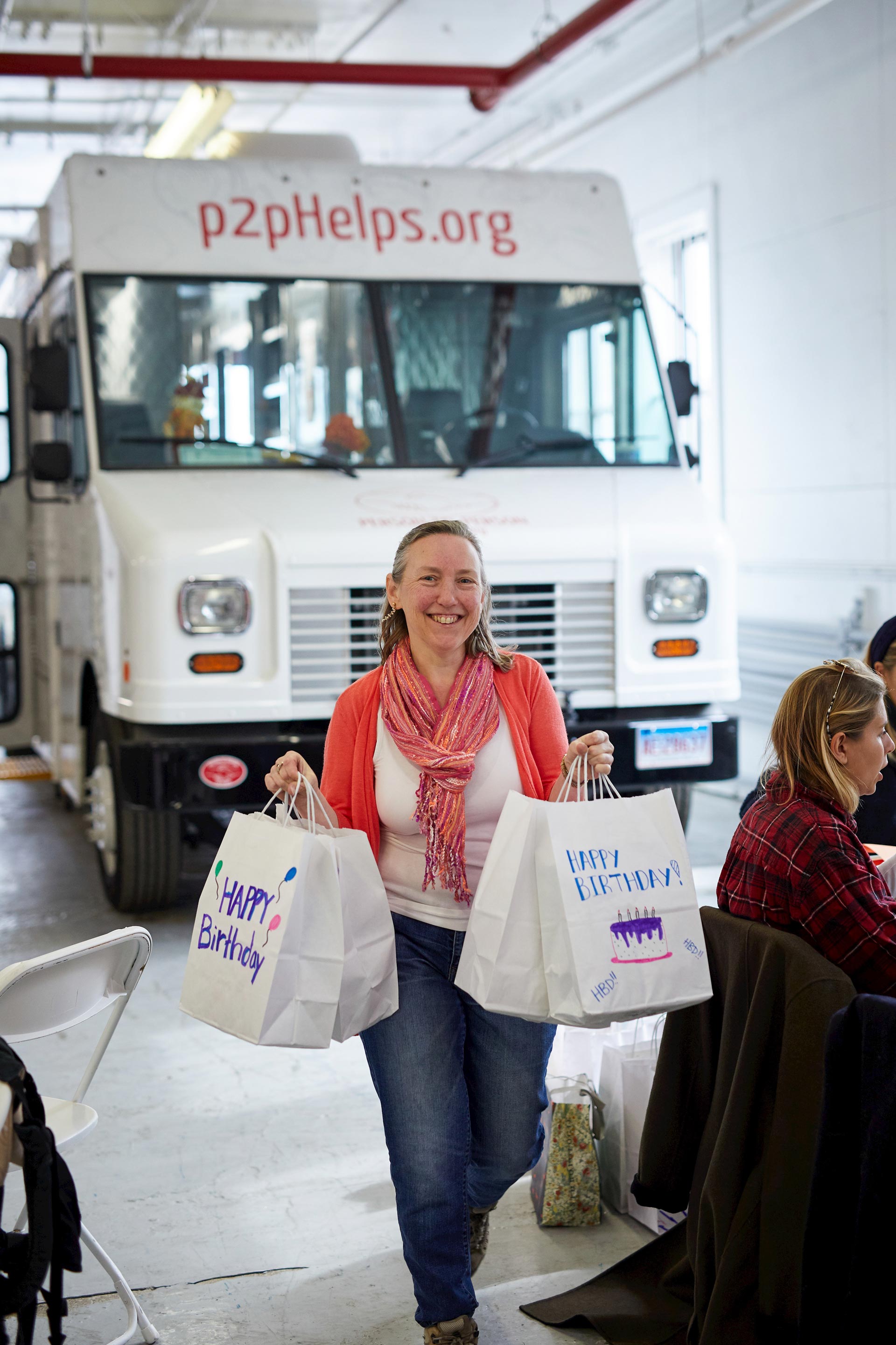 Photo of Jen Donnaley in front of p2pHelps.org bus