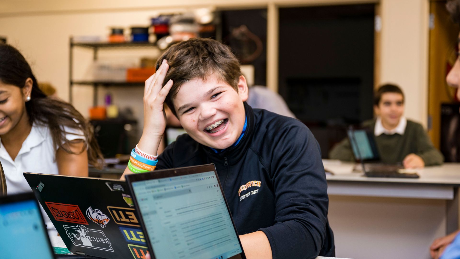 Photo of student laughing while reading a book 